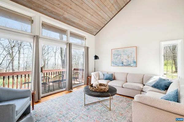 a living room with furniture and a floor to ceiling window