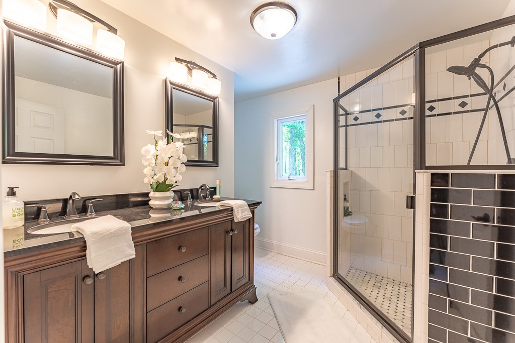 220 Hibiscus Drive Rochester, NY 14618 - Photo 38 of 50 The beautifully updated spa-like primary bath features an oversized glass and tile shower and double vanity.