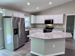 20193 Southwest 83rd Street Dunnellon, FL 34431 - Photo 18 of 31 a kitchen with kitchen island a counter top space a refrigerator and a sink