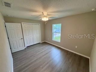 20193 Southwest 83rd Street Dunnellon, FL 34431 - Photo 20 of 31 an empty room with wooden floor fan and windows