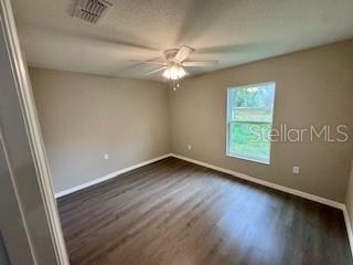 20193 Southwest 83rd Street Dunnellon, FL 34431 - Photo 26 of 31 an empty room with wooden floor fan and windows