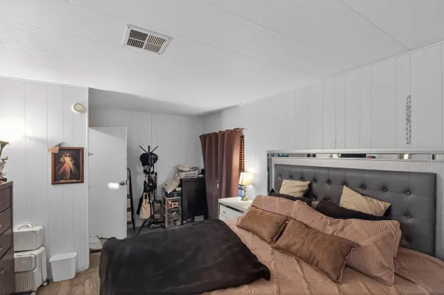 a bedroom with a bed and wooden floor