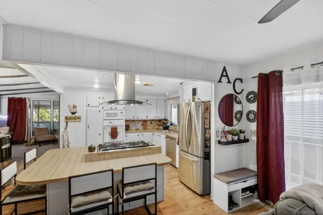 a kitchen with stainless steel appliances granite countertop a sink and a refrigerator