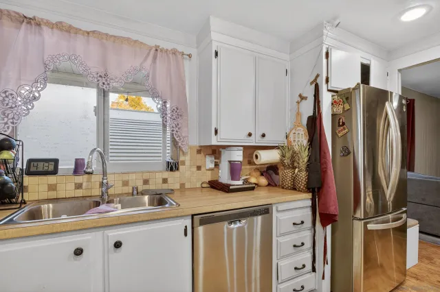 a kitchen with stainless steel appliances a sink and a refrigerator