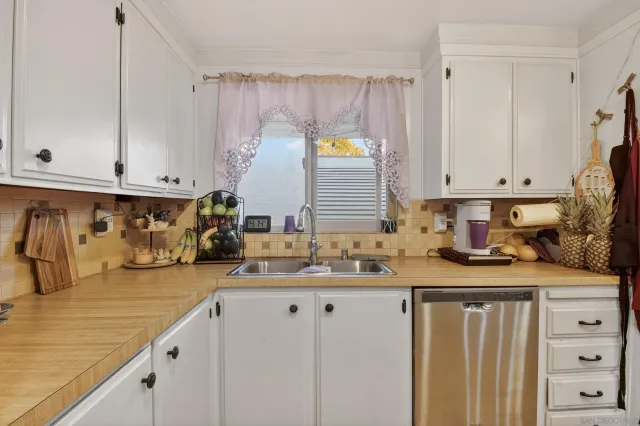a kitchen with granite countertop a sink a stove and cabinets