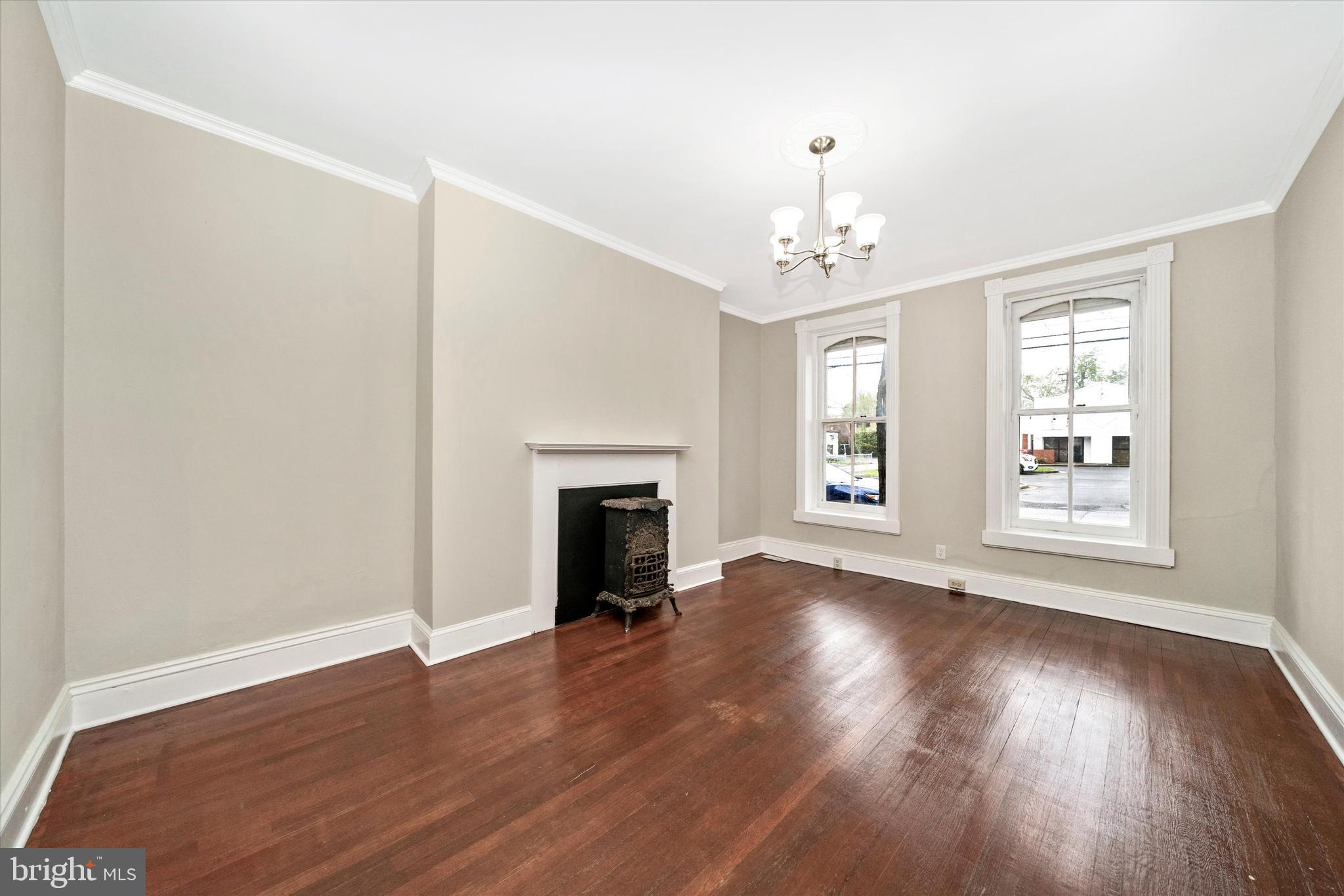 129 West 4th Street Frederick, MD 21701 - Photo 9 of 70 an empty room with wooden floor chandelier and windows
