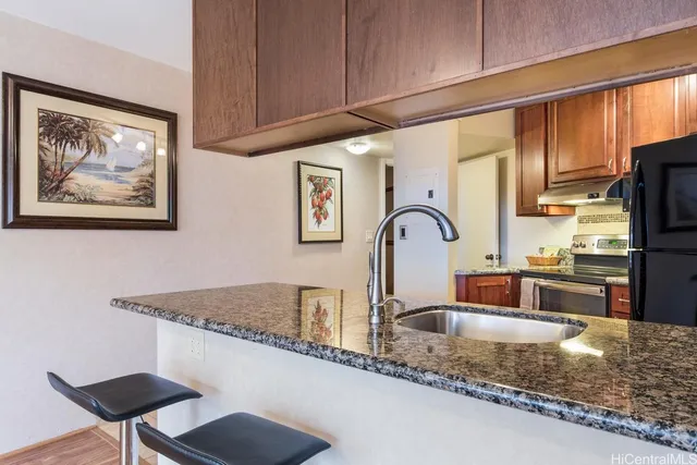a kitchen with granite countertop a stove a sink and a microwave