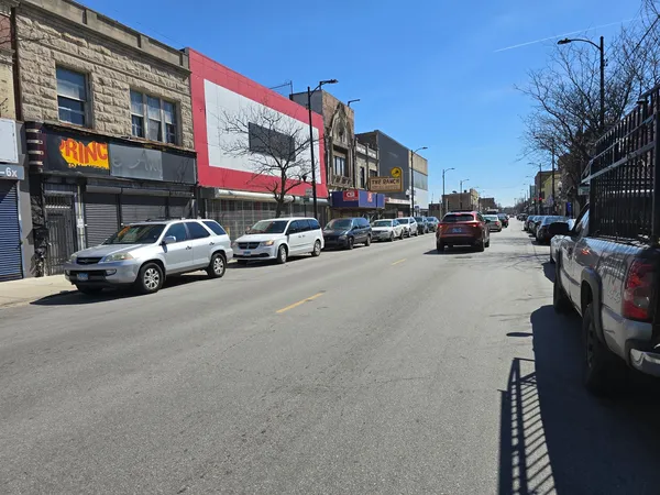a view of a city street with parked cars