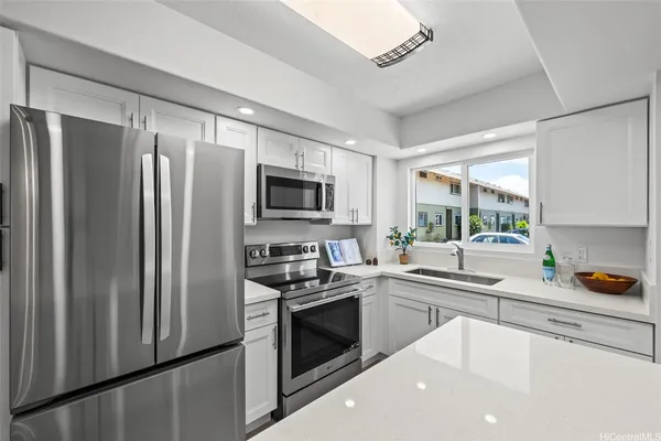 a kitchen with stainless steel appliances a refrigerator sink and microwave