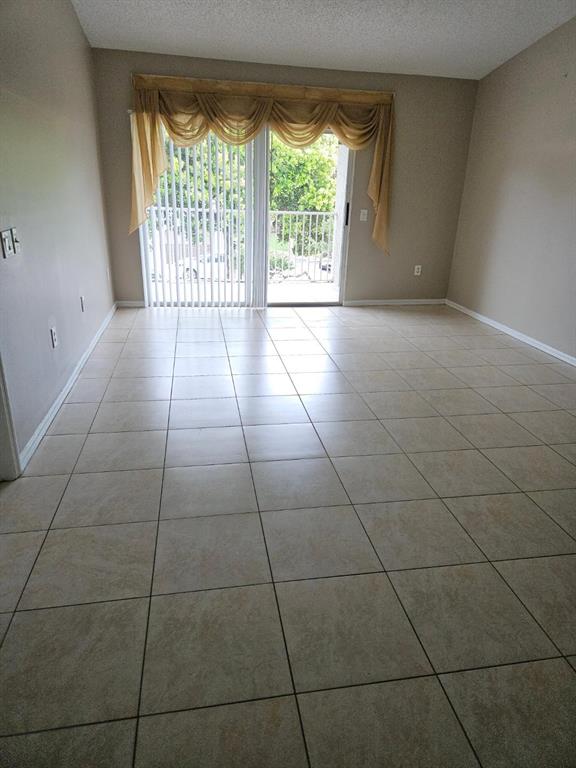 5041 Wiles Road, Unit 201 Coconut Creek, FL 33073 - Photo 16 of 17 a view of an empty room with a floor to ceiling window and an empty room