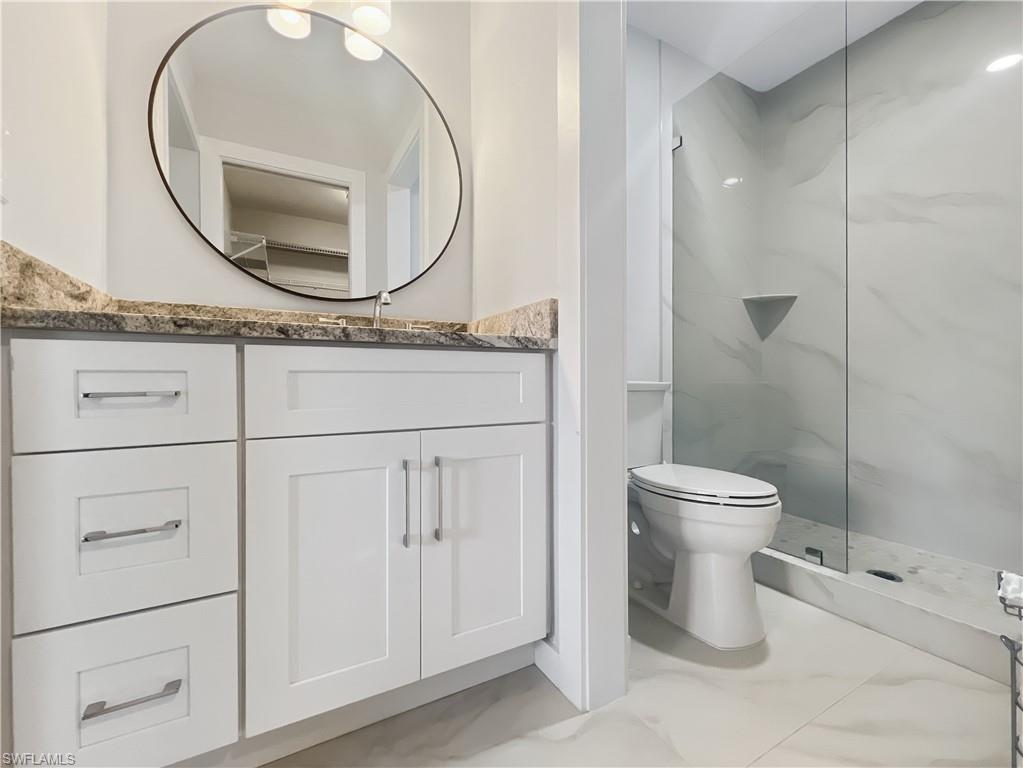5908 Cranbrook Way, Unit I202 Naples, FL 34112 - Photo 26 of 45 a bathroom with a toilet a sink and mirror