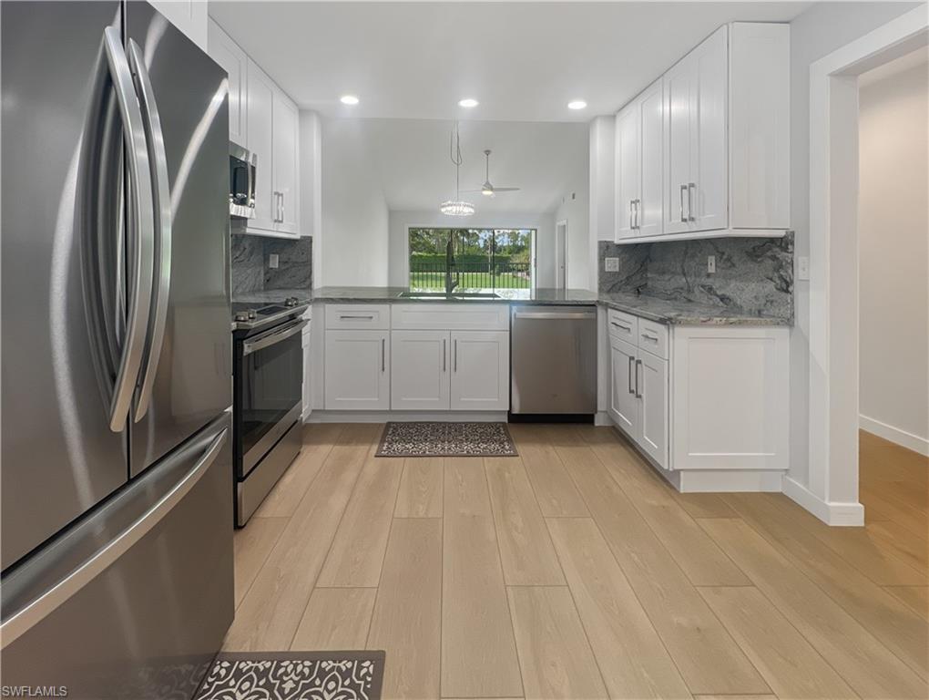 5908 Cranbrook Way, Unit I202 Naples, FL 34112 - Photo 6 of 45 a kitchen with stainless steel appliances granite countertop a refrigerator and a stove top oven