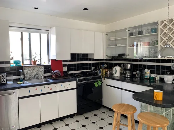 a kitchen with stainless steel appliances a stove a sink a counter space and a window