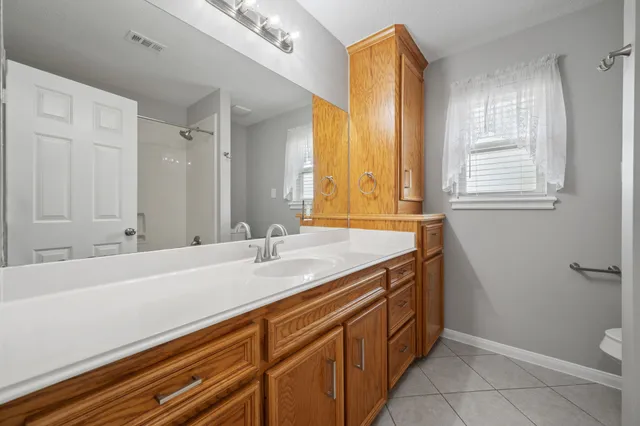 a spacious bathroom with a granite countertop sink and a mirror