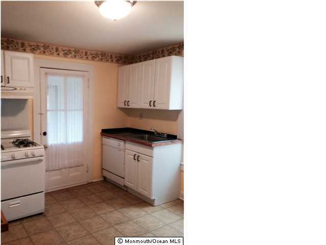 42 Washington Street Red Bank, NJ 07701 - Photo 5 of 6 a kitchen with a stove and white cabinets