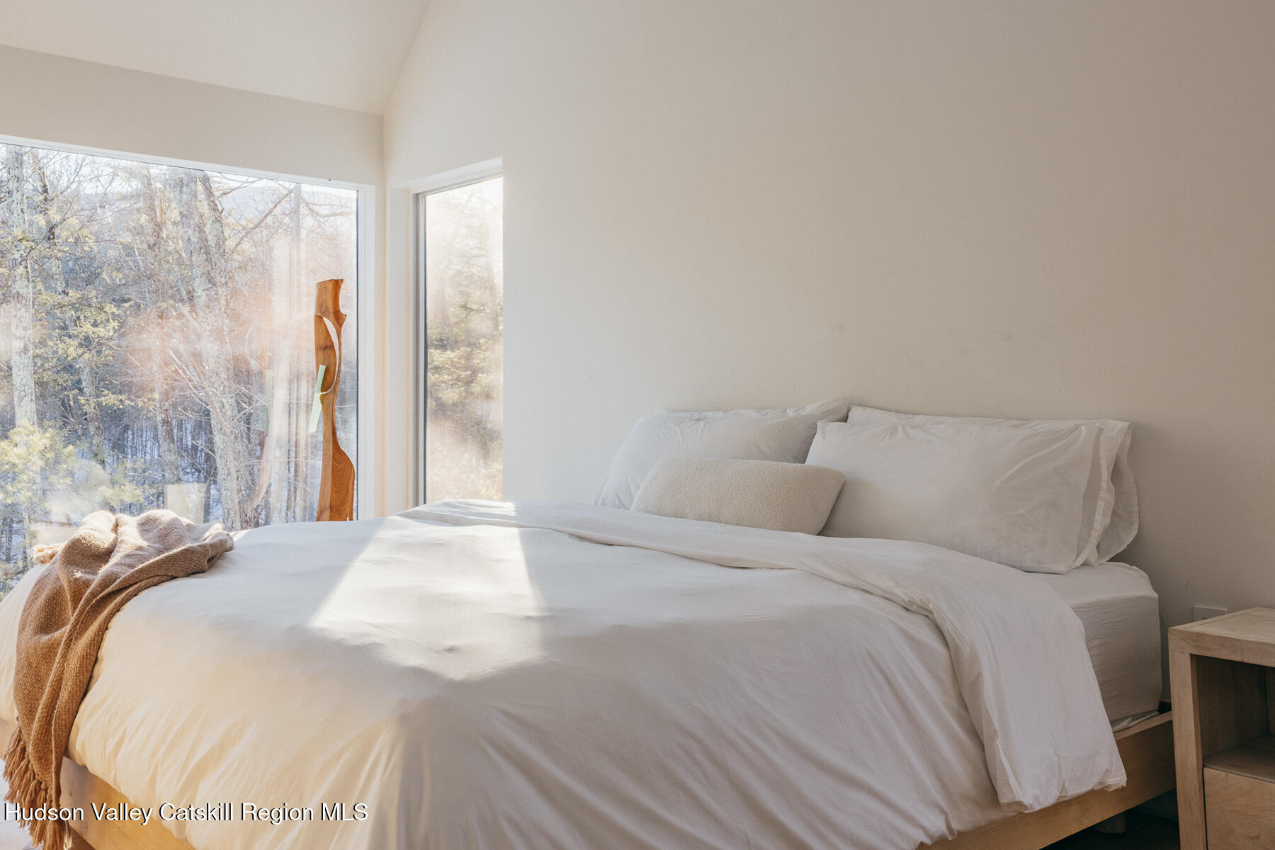 261 Blackhead Mountain Road Round Top, NY 12473 - Photo 28 of 40 a large white bed in a bedroom next to a window and a bathroom