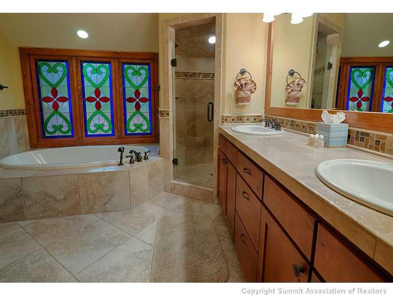 1005 4 O Clock Road Breckenridge, CO 80424 - Photo 14 of 24 a bathroom with a granite countertop sink a large mirror a bathtub and a painting on the wall