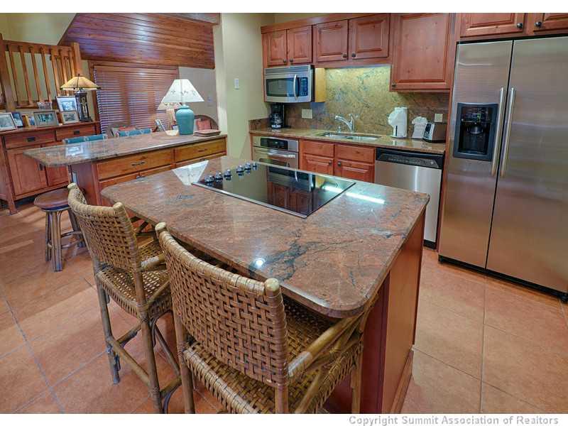 1005 4 O Clock Road Breckenridge, CO 80424 - Photo 7 of 24 a kitchen with stainless steel appliances granite countertop a table chairs sink and cabinets