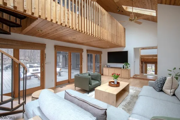 a living room with furniture a flat screen tv and a large window