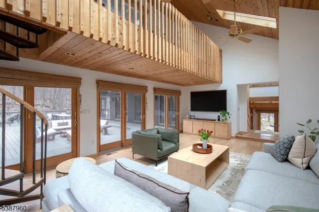 a living room with furniture a flat screen tv and a large window