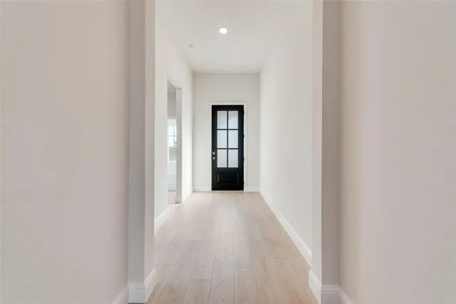 a view of a hallway with wooden floor and a white cabinet