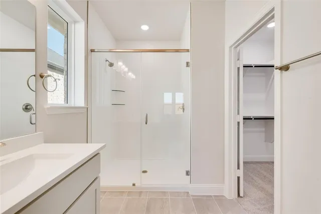 a bathroom with a shower sink and mirror
