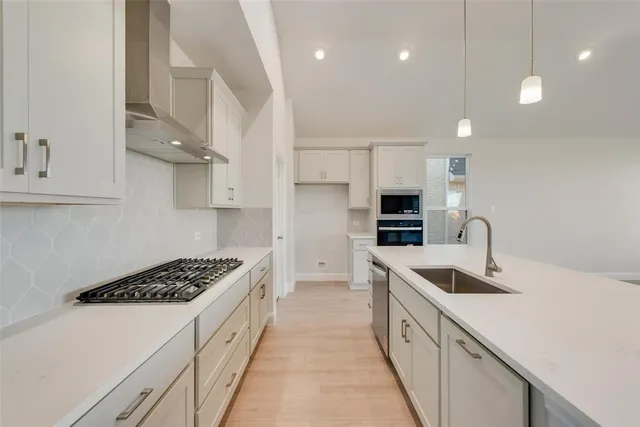 a kitchen with stainless steel appliances sink a microwave and cabinets