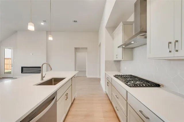 a kitchen with stainless steel appliances kitchen island a sink stove and cabinets