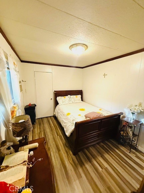 16601 Garfield Avenue, Unit 110 Paramount, CA 90723 - Photo 13 of 22 a bedroom with a bed and wooden floor