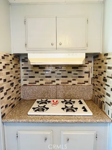 a kitchen with cabinets appliances a sink and a counter top space
