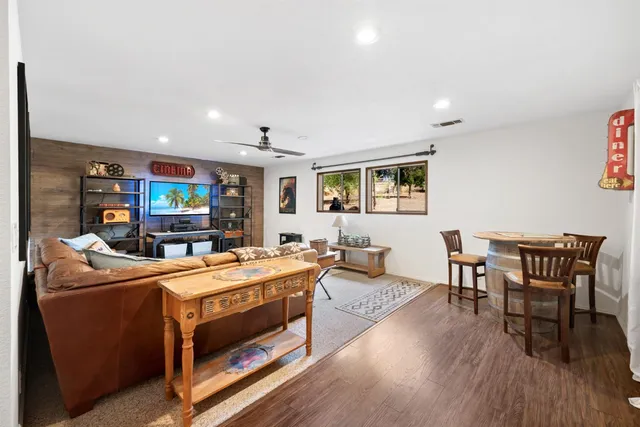a living room with furniture a large window and a flat screen tv