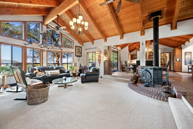 a living room with furniture kitchen view and a chandelier