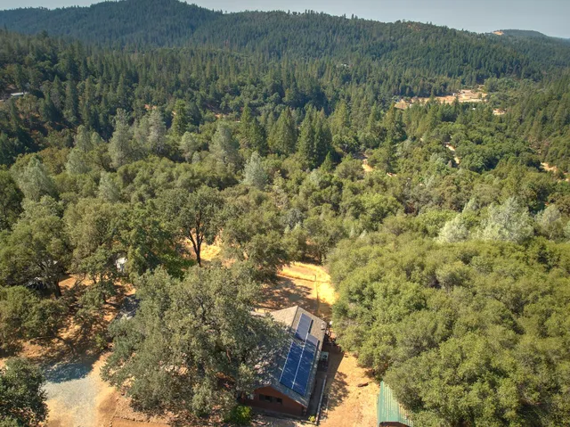 a view of a houses with yard and trees