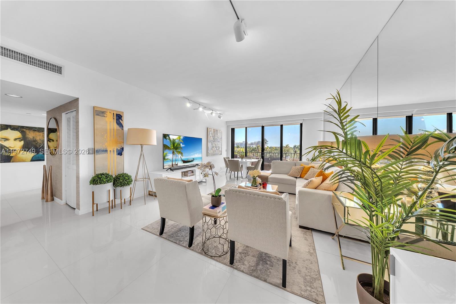a living room with furniture a chandelier and a dining table with wooden floor
