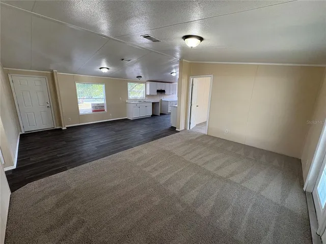 an empty room with windows and cabinet