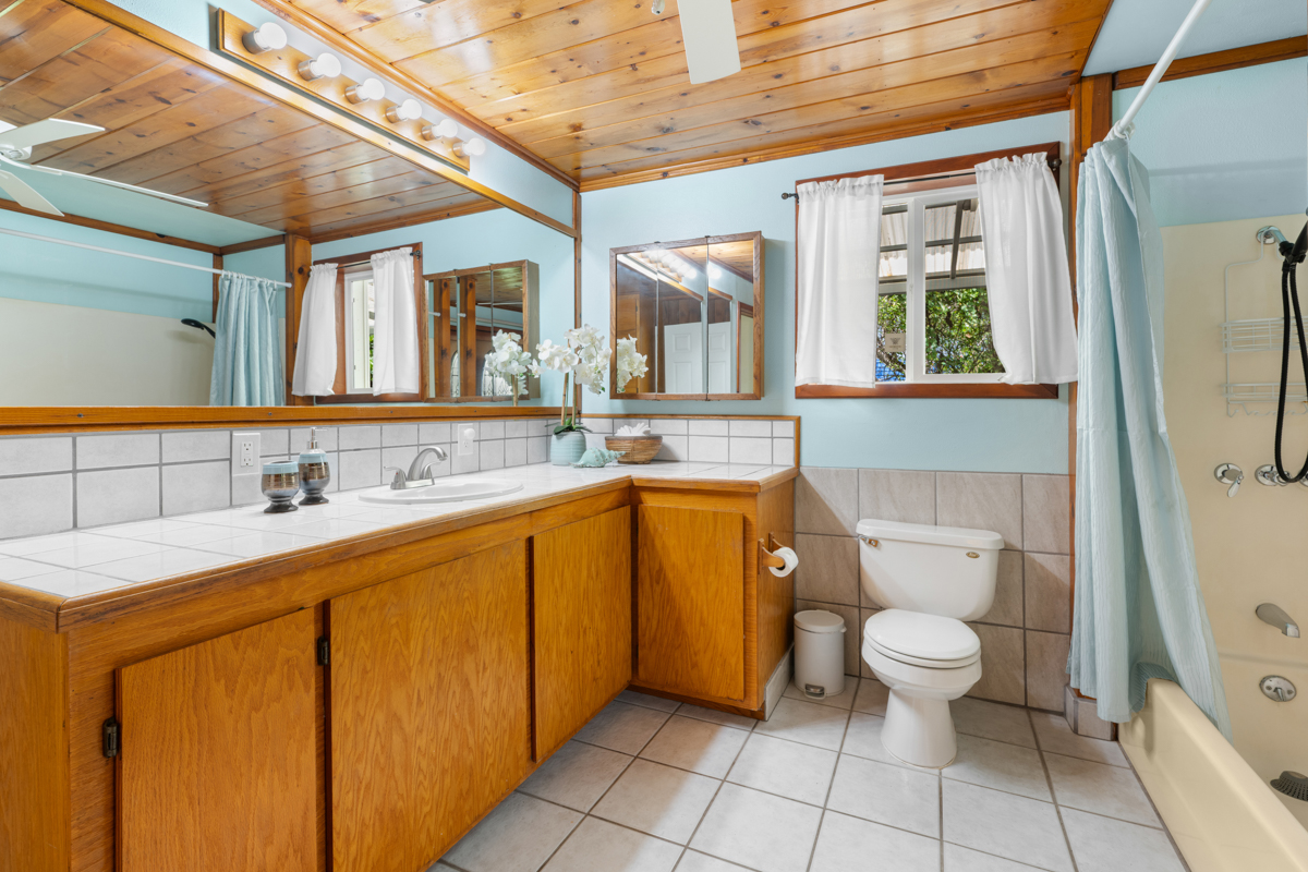76-6179 Mania Road Kailua-Kona, HI 96740 - Photo 22 of 30 a bathroom with a granite countertop sink toilet and mirror