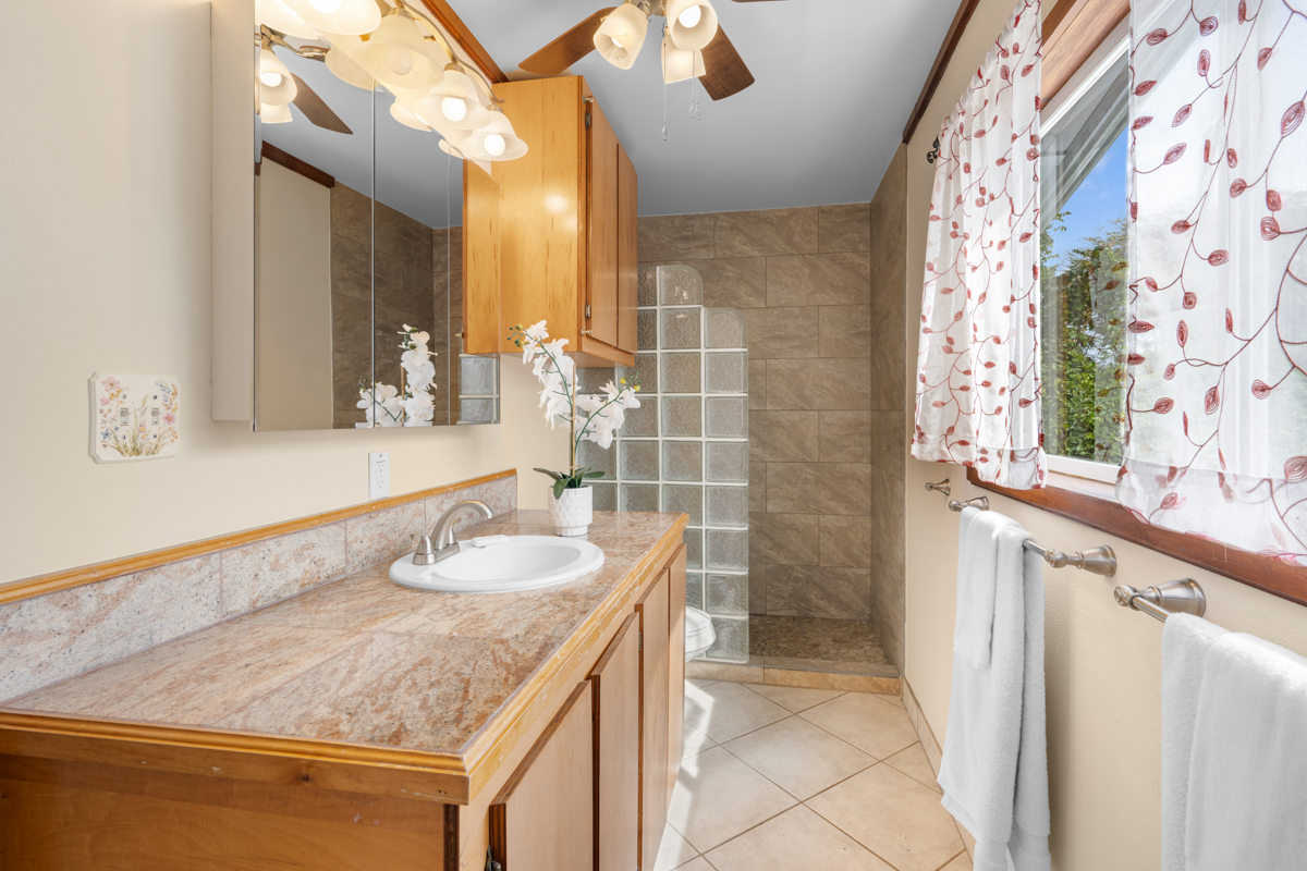 76-6179 Mania Road Kailua-Kona, HI 96740 - Photo 10 of 30 a bathroom with a granite countertop sink a toilet and a mirror