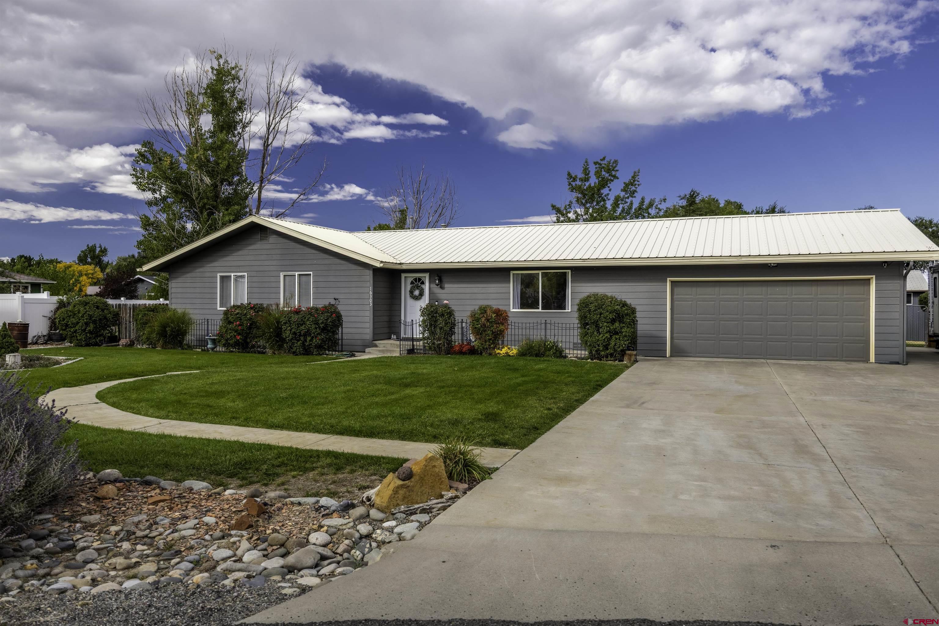 16303 6420th Road Montrose, CO 81403 - Photo 1 of 31 a front view of a house with a yard and garage