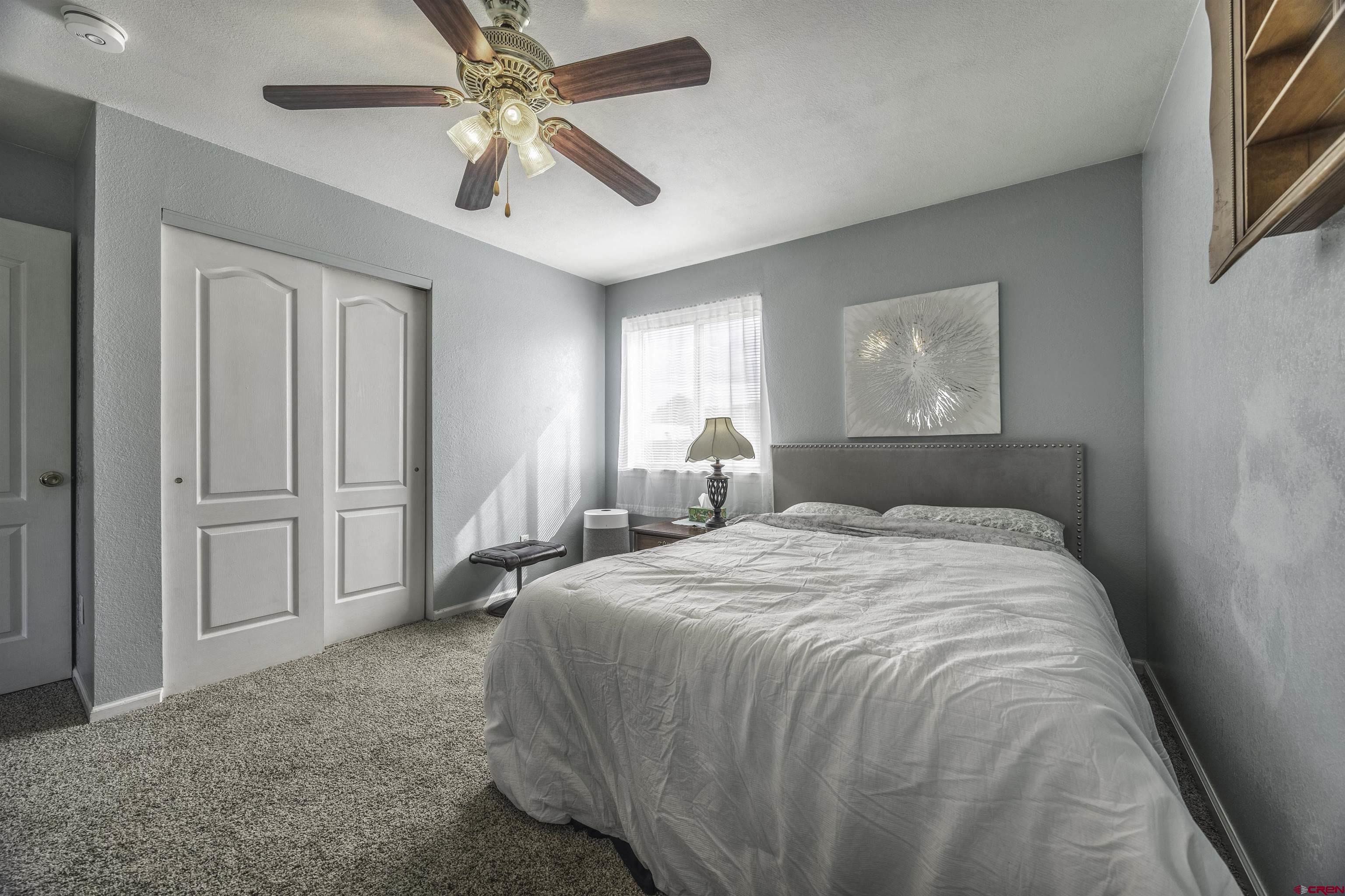 16303 6420th Road Montrose, CO 81403 - Photo 16 of 31 a spacious bedroom with a bed and a chandelier