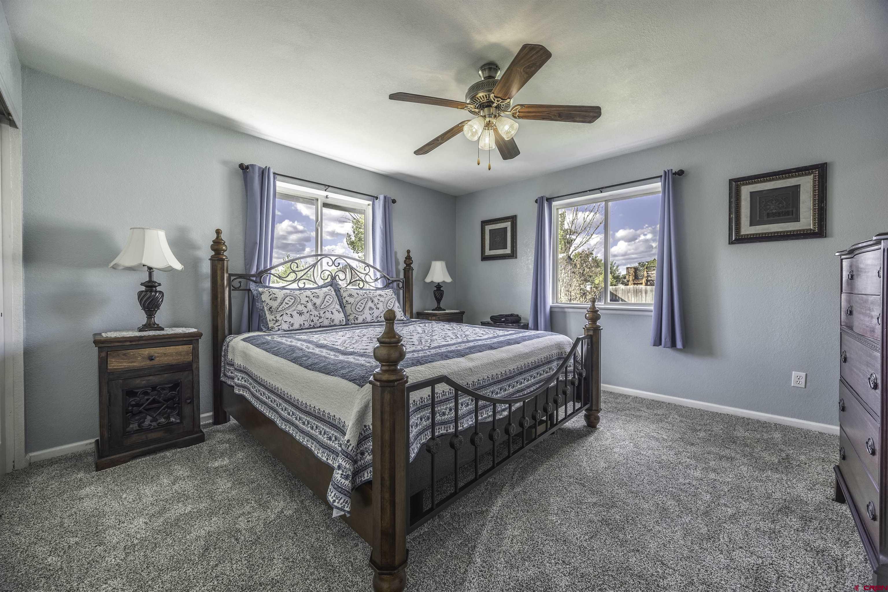 16303 6420th Road Montrose, CO 81403 - Photo 17 of 31 a bedroom with a bed chandelier and a window