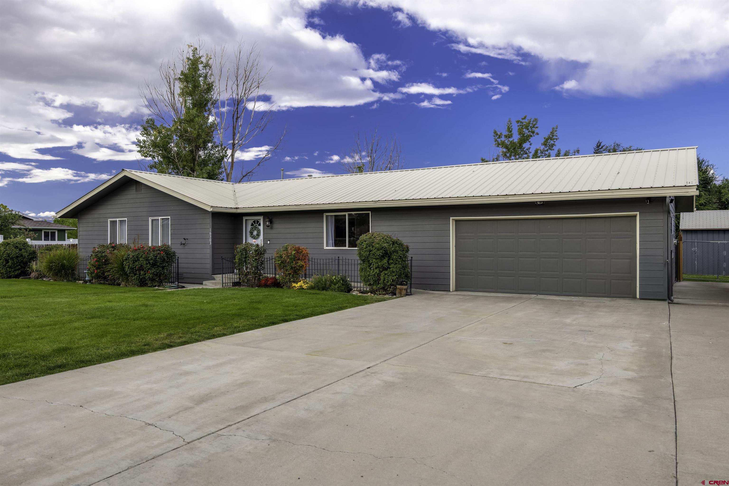 16303 6420th Road Montrose, CO 81403 - Photo 23 of 31 a front view of a house with a yard and garage