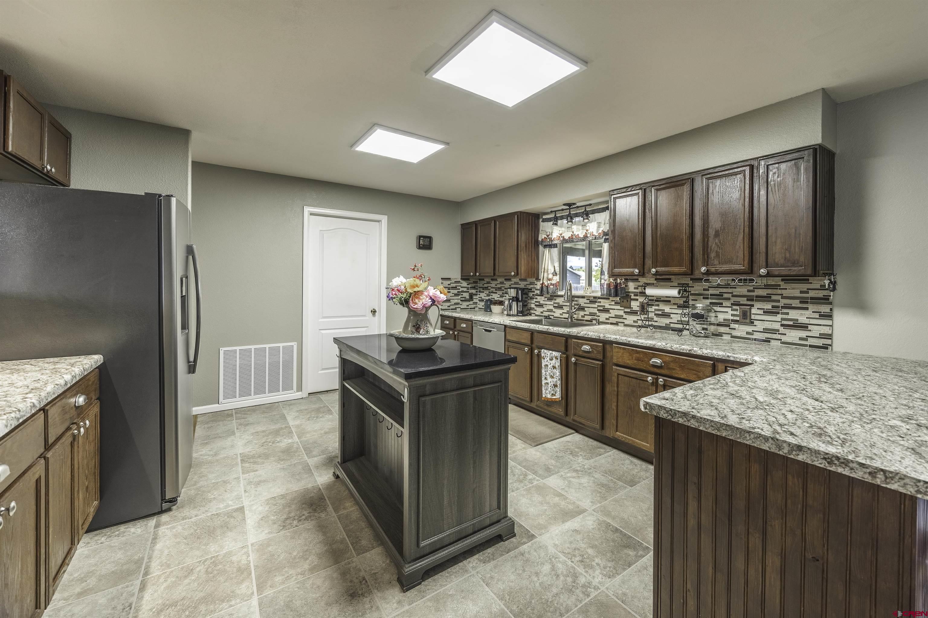 16303 6420th Road Montrose, CO 81403 - Photo 8 of 31 a kitchen with stainless steel appliances granite countertop a sink stove and refrigerator