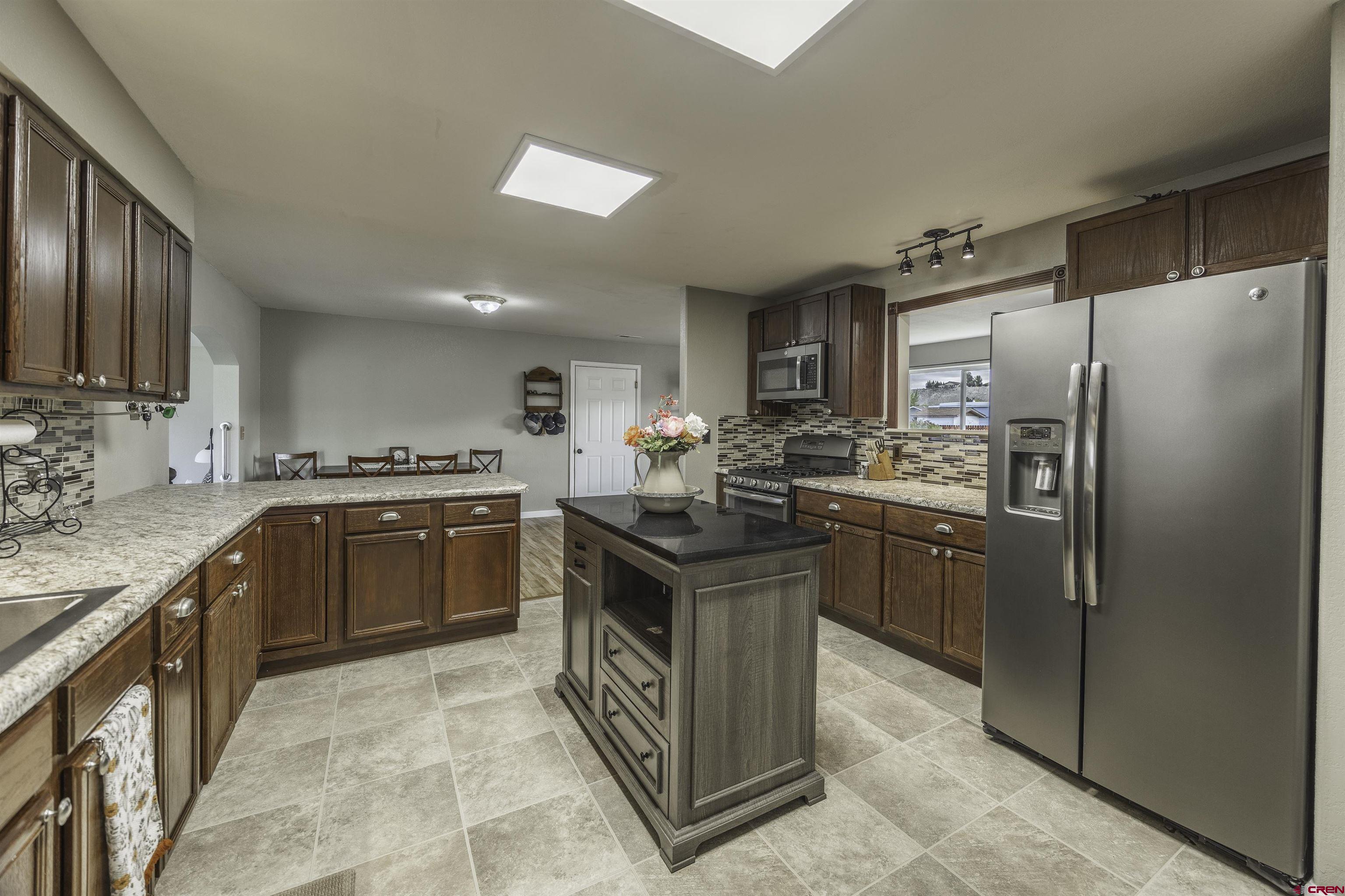 16303 6420th Road Montrose, CO 81403 - Photo 9 of 31 a kitchen with stainless steel appliances granite countertop a stove refrigerator and a sink