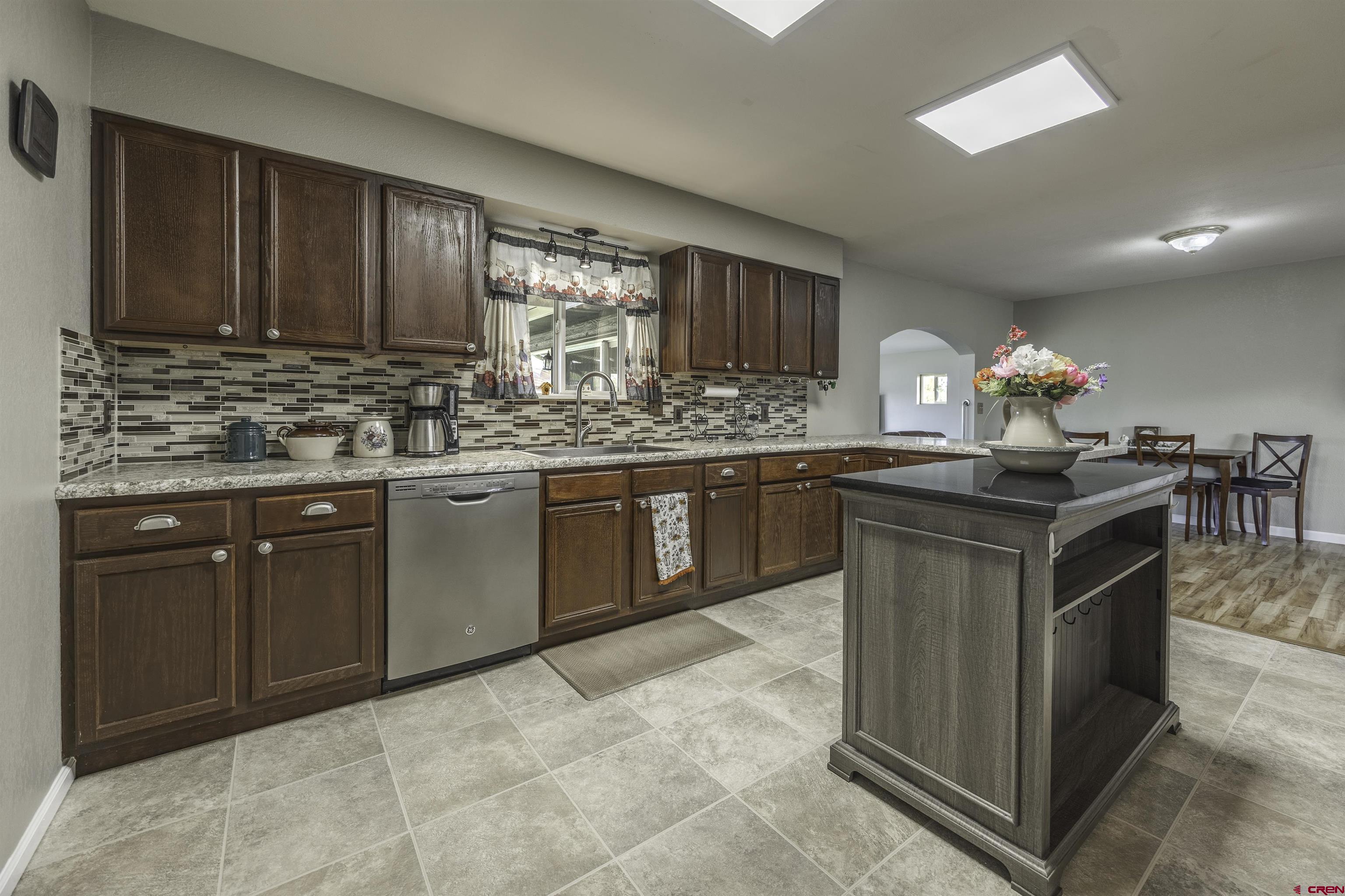 16303 6420th Road Montrose, CO 81403 - Photo 10 of 31 a kitchen with kitchen island granite countertop a sink cabinets and stainless steel appliances