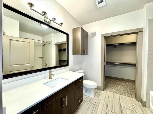 a bathroom with a sink a toilet and a mirror