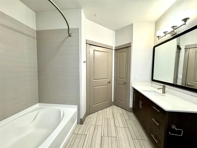 a bathroom with a tub sink shower and mirror