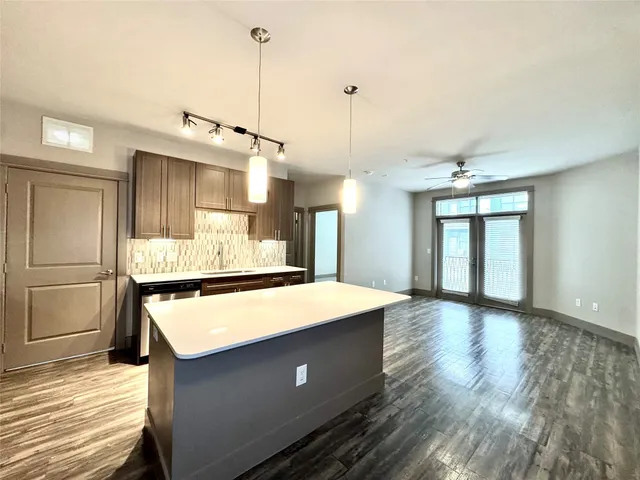 a large kitchen with kitchen island a stove a sink dishwasher and wooden floor