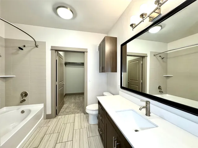 a bathroom with a tub sink and mirror