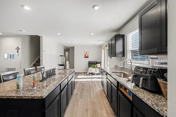 a kitchen with kitchen island granite countertop a stove top oven microwave and refrigerator
