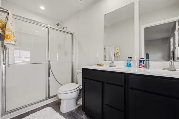 a bathroom with a sink toilet a mirror and shower